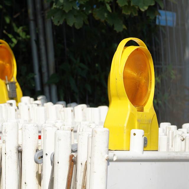 Hintereinander stehend gestapelte Absperrungen für Straßensperrungen mit zwei Lichtern.