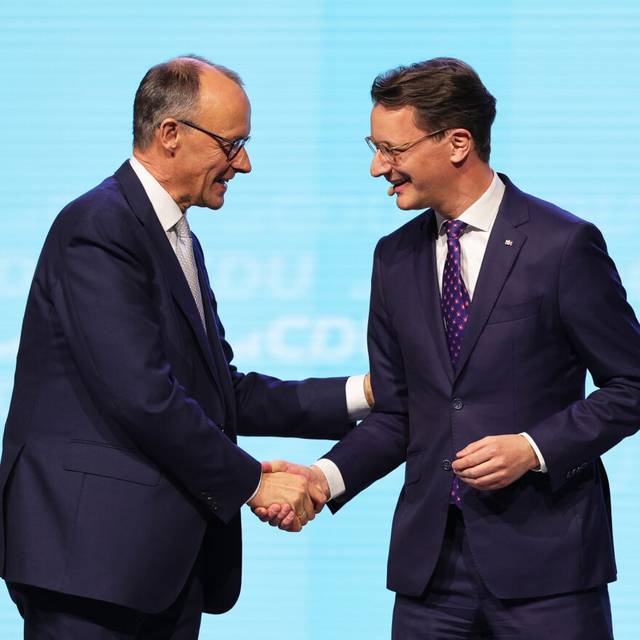 Friedrich Merz (l), CDU-Bundesvorsitzender und Unions-Kanzlerkandidat, und Hendrik Wüst (CDU), Ministerpräsident von Nordrhein-Westfalen, geben sich bei einer Wahlkampfveranstaltung der CDU in der Rudolf Weber-Arena auf der Bühne die Hand.