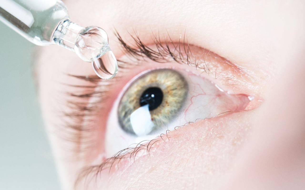 Frau benutzt befeuchtende Augentropfen