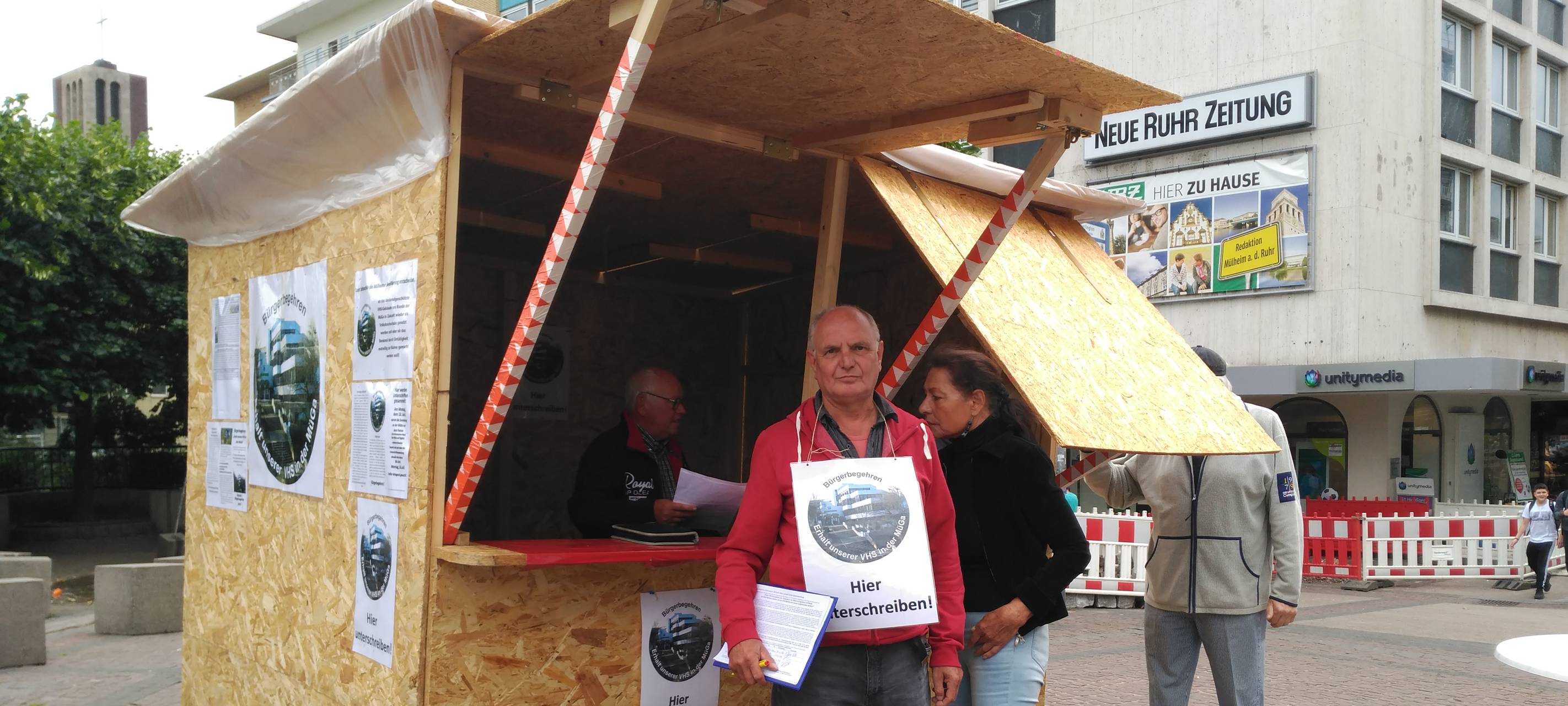 Unterschriftenaktion fürs Bürgerbegehren für den Erhalt der VHS in der MüGa, Infostand bleibt bis zu den Sommerferien auf dem Kurt-Schumacher-Platz stehen