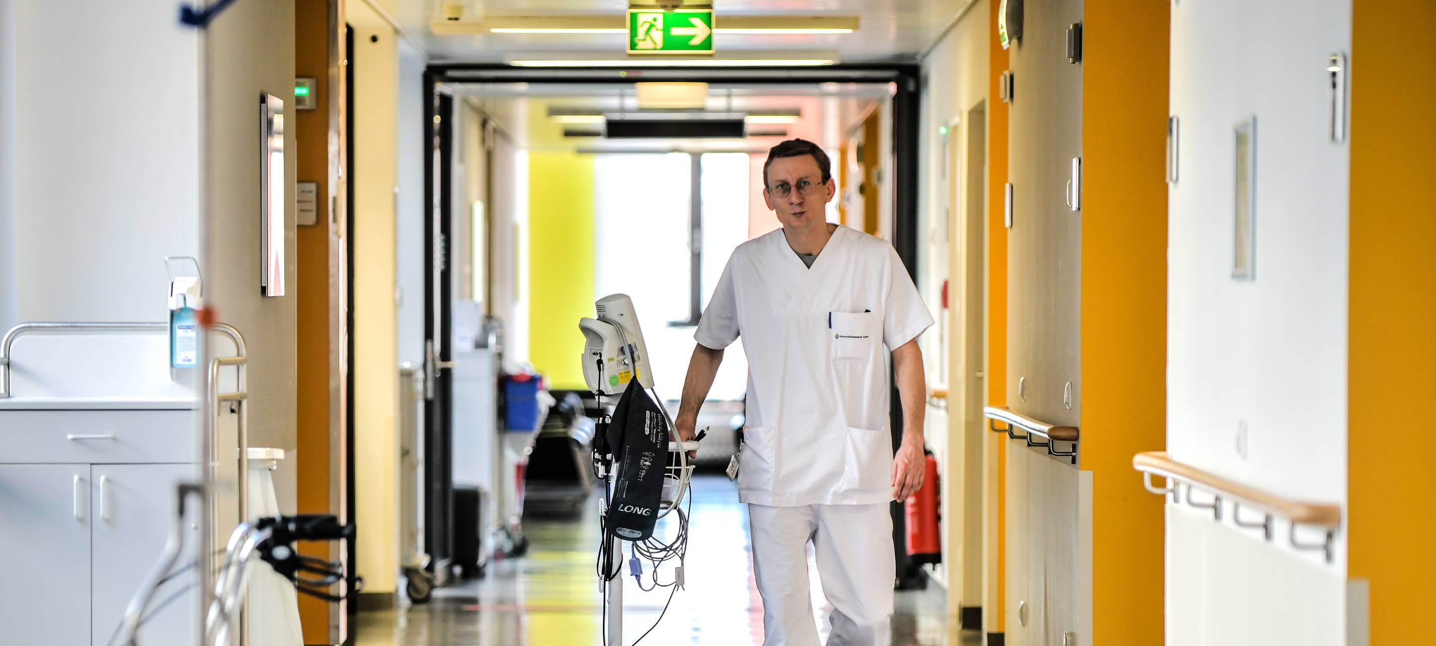 Ein Krankenpfleger geht über den Gang in einer Station des Universitätsklinikums Essen.