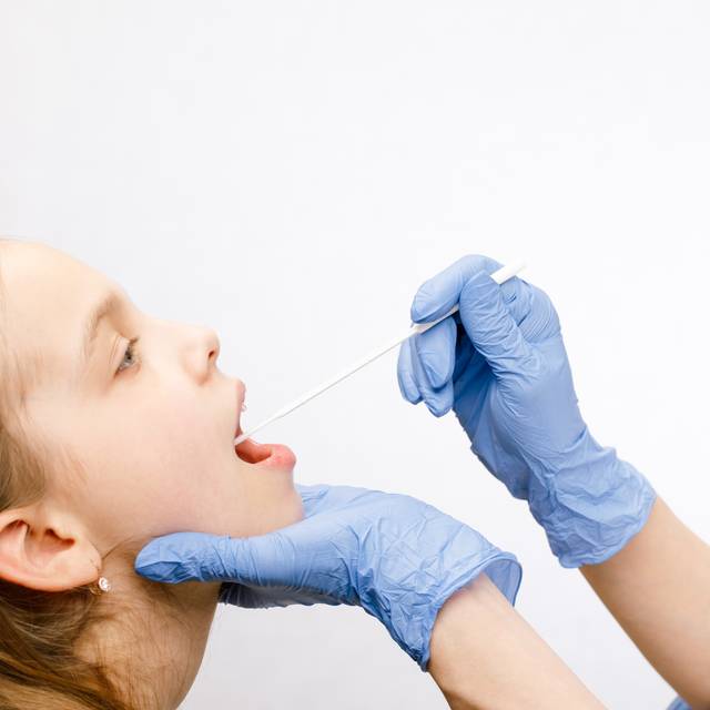 Arzt, der Speichelprobe aus dem Mund des Patienten entnimmt und dabei das diagnostische Verfahren für Speicheluntersuchungen durchführt.